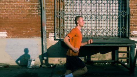 Man jogging though warehouse district of Los Angeles. Slow Motion.