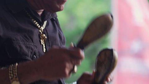 Havana, Cuba, October 2016: Musician playing maracas, traditional musical instrument. Tourism and travel in La Habana Vieja, Old Havana, Cuba. Slow motion and closeup of hands
