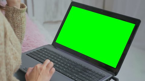 Woman using laptop with green screen. Business, communication, freelance and internet concept