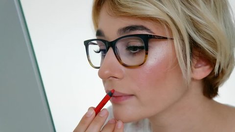 Beautiful girl doing makeup lips close up. Red lip stick makeup 