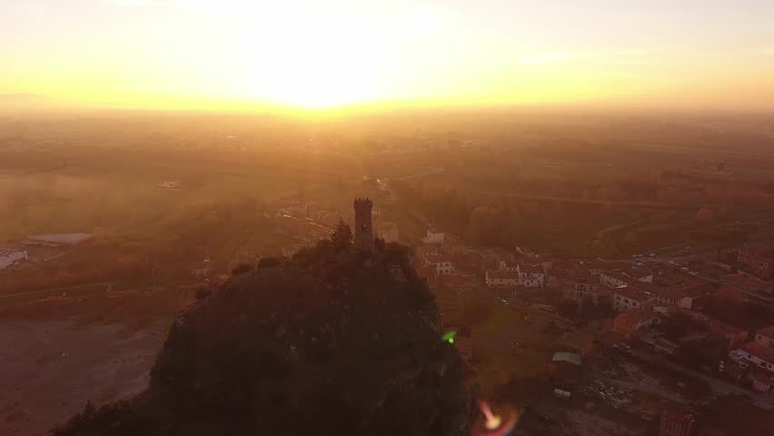 Aerial shot, Upezzinghi tower on the rocky outcrop in Italy, Tuscany, on the sunset light, filmed with drone