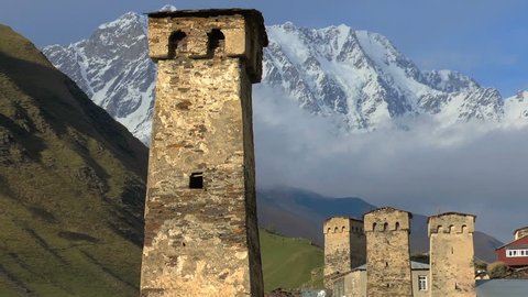 Svaneti Old village in Georgia. Medieval tower built for defensive purposes. Each family had its own tower. In the background is seen the Caucasian mountains and clouds.