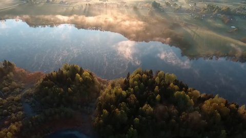 Aerial View. Flying over the beautiful river in clouds . Aerial camera shot. Sunrise. Landscape panorama. Belarus.