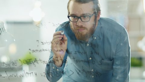 Close-up of a Man Writing Formulas on a Glass Whiteboard. Shot on RED Cinema Camera in 4K (UHD).