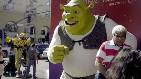LOS ANGELES - OCT 23, 2016: Tourists Posing In Front Of Shrek Statue On Hollywood Boulevard In LA California. HW Blvd is a major thoroughfare and tourist attraction in Los Angeles.