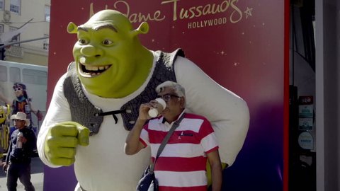 LOS ANGELES - OCT 23, 2016: Indian Man And Wife Posing With Shrek Statue On Hollywood Boulevard In LA CA. HW Blvd is a tourist attraction with many statues and actors dressed as film characters.