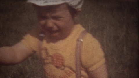 Family Chronicle: Little boy crying. Father shooting family video on 8mm camera
