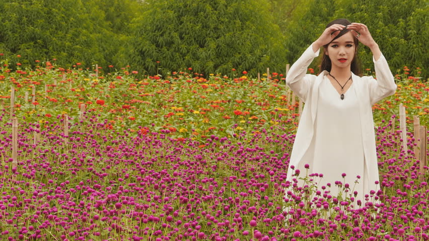 Vietnamese girl with long black hair standing in a plantation purple flowers