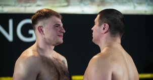Two boxers face-off looks for each other before fight 4k video in boxing ring. Close-up view