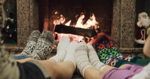 Cinemagraph - Feet in woolen socks warming by cozy fire in Christmas time in slow motion. Loop. Family with two kids warming their feet by the fireplace in winter time. 120 fps 4k motion photo. Adlı Stok Video