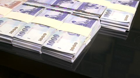 Putting down stacks of thousand of New Taiwan Dollar bills