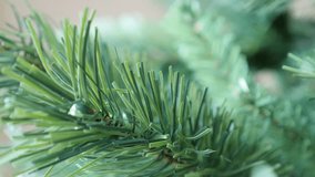 Panning on green needles of artificial Christmas tree branches 4K 2160p 30fps UltraHD  footage - New Year night celebration plant background shallow DOF 3840X2160 UHD pan video