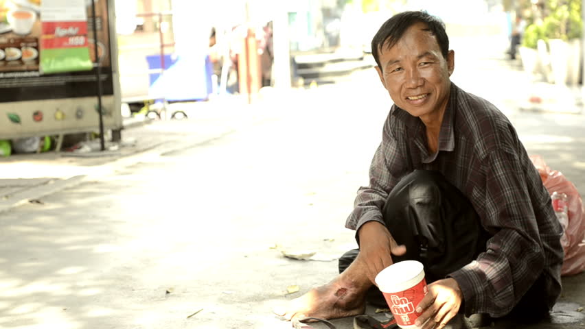 BANGKOK - CIRCA MAY 2012: Homeless man begging on a sidewalk circa May 2012 in