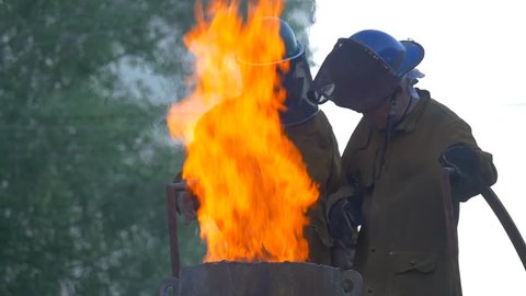 Wroclaw/poland - Jun 18 2016: Festival of High Temperatures in Wroclaw City, Poland. Workers Are Looking Down Into Furnace, Orange Flame is Rising Up, Slow Motion. Craftsmen From All Over the World