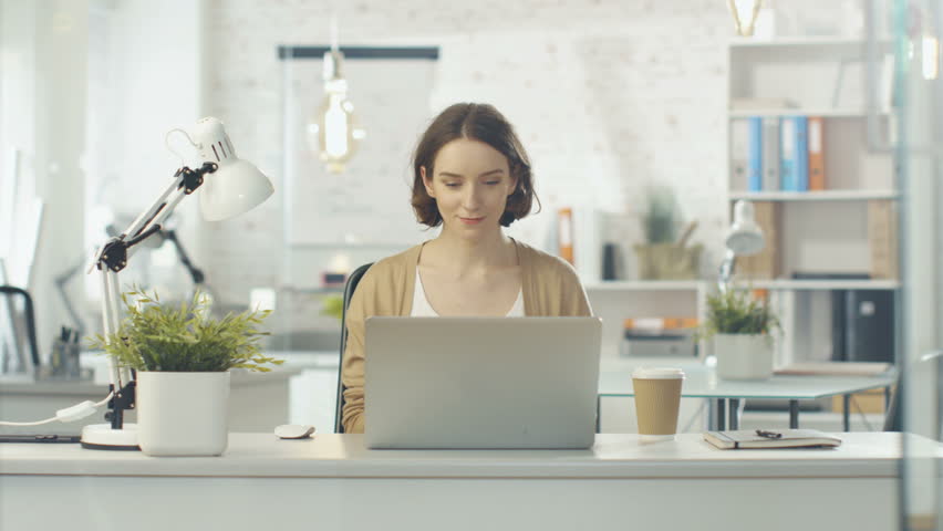 Portrait Shot of a Creative Woman Sitting at Her Desk. Using Notebook. She Sits in a Light and Modern Office. Shot on RED Cinema Camera in 4K (UHD). | Shutterstock HD Video #22232101