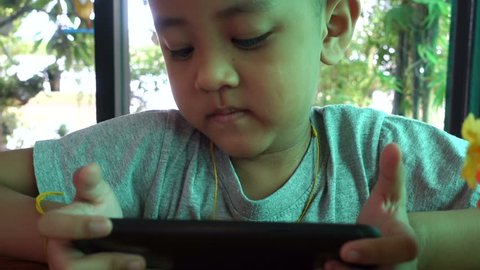 Asian boy playing games on smart phone