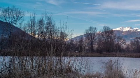 park with a frozen lake in the winter and mountains background, timelapse, hyperlapse video