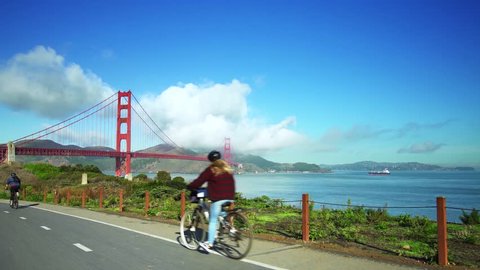 People ride bikes on road near Golden Gate Bridge and San Francisco bay 3