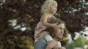 Close up panning shot of father carrying daughter on shoulders / Orem, Utah, United States