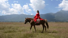 A pretty girl riding a horse on the grassland