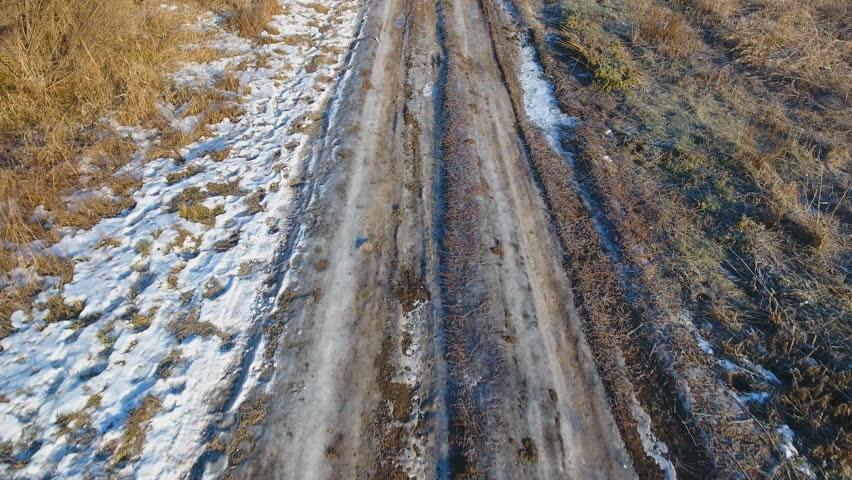 Gravel country road in winter time. Aerial view.