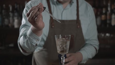 bartender preparing cocktail with bar equipment, throw sieve and spray it