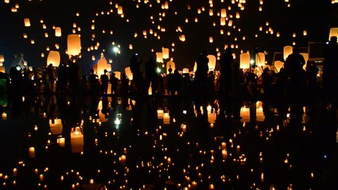 Many Sky Fire Lanterns Floating Up To The Sky In Yee Peng Lanna International 2016 And Reflection on Water Landmark Destination Travel Of Chiang Mai, Thailand (tilt up)