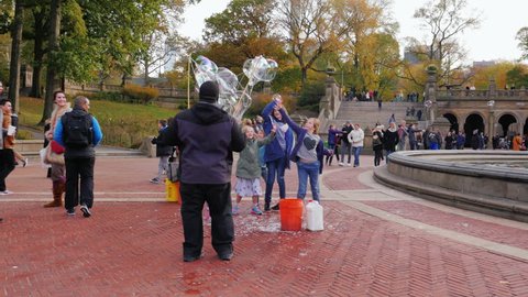New York, USA - OKT, 2016: Man entertains kids - blow bubbles in Central Park, New York