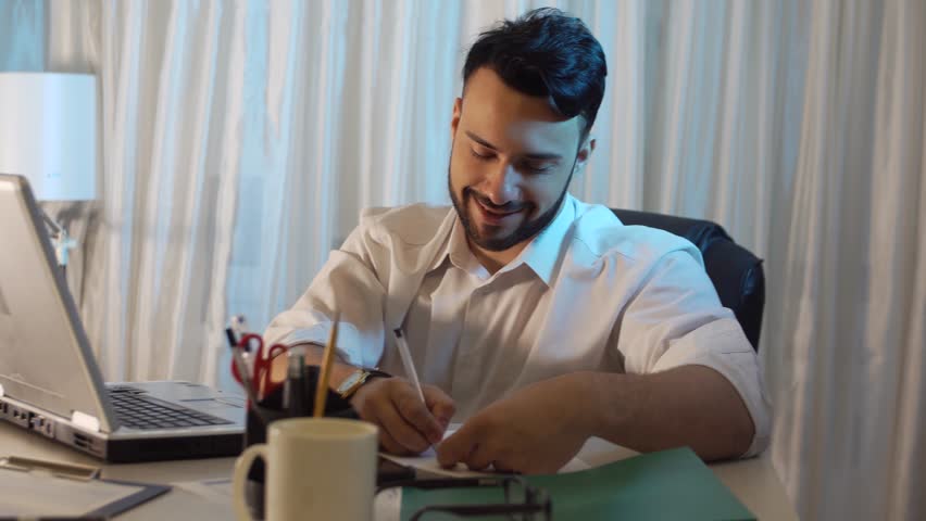 Young trendy businessman in office taking notes and working on the laptop | Shutterstock HD Video #22270021