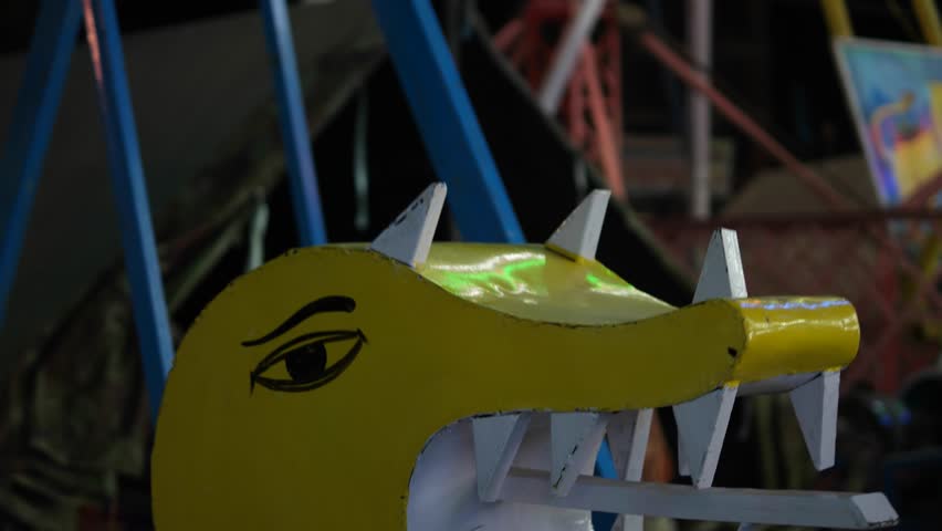 Close up of carnival lights, ferris wheel, giant rides in an amusement park at fairgrounds in Asia at night time