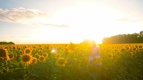 Girl with phone in field of sunflowers teen girl talking on the phone in sun yellow sunflowers on sunset