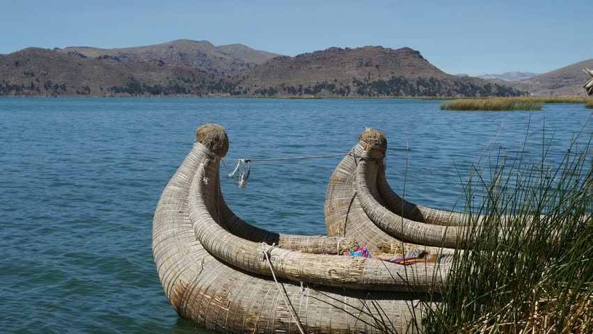 View of the Uros floating reed islands with boats, mysterious Lake Titicaca, Puno Region, Peru