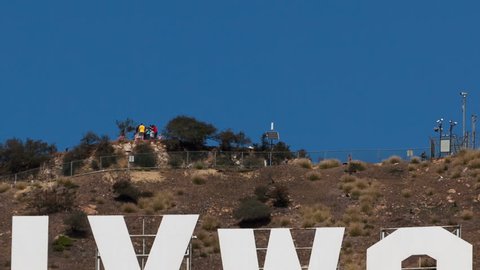 LOS ANGELES, CA, USA - MAR 03, 2012: Time lapse close up zoom out Hollywood sign on Santa Monica mountains with people sightseeing on the platform behind