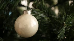 Beautiful Christmas tree and reflective bauble with blinking dot lights 4K 2160p 30fps UltraHD footage - Shiny glass white ornament for New Year night decorations close-up 3840X2160 UHD video