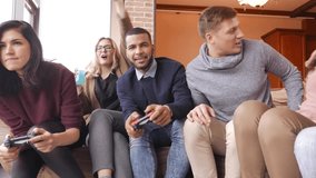 Group of multi ethnic friends having fun playing on game console in home interior