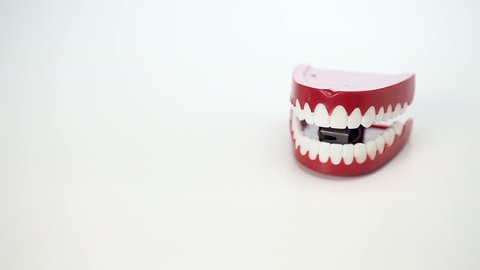 This is a video of toy chattering teeth moving on a white background to symbolize fun concepts of comedy,dentistry,etc.