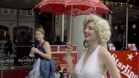 LOS ANGELES - NOV 1, 2016: Marilyn Monroe Impersonator Smiling At Baby And Waving At Tourists On Hollywood Boulevard In LA California. Tourists enjoy performances and impersonations of famous icons.