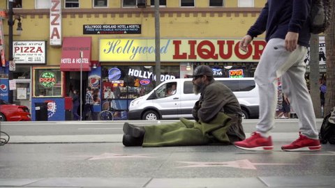 LOS ANGELES - NOV 1, 2016: Itchy Homeless Man Scratching Himself Sitting On Street Hollywood Boulevard Walk Of Fame Stars Outside Liquor Store In 60p In LA CA.