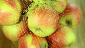 Close up of many riped apples in shop packaging on wooden brown background rotating. Real time full hd video footage.