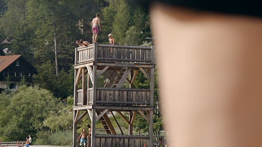 A young adoult doing a stunt backflip jump from a height in a lanke