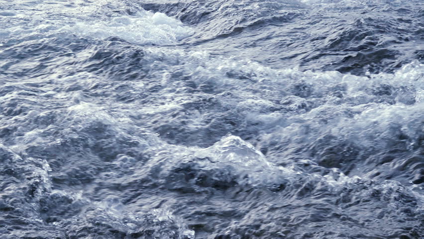 Flowing water in a blue river in slow motion