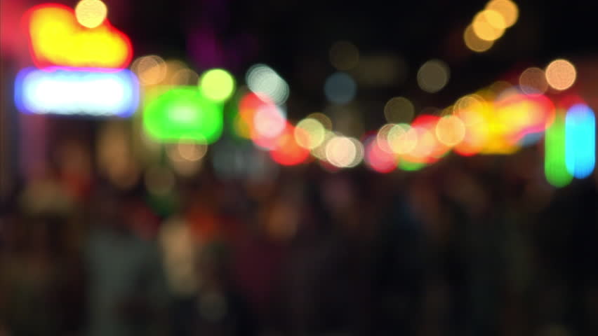 People enjoying famous Bourbon Street at night in the French Quarter of New Orleans, Louisiana, blurred
