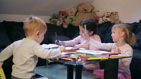 3 little kids drawing, indoors,  2, 4 and 6 year old
