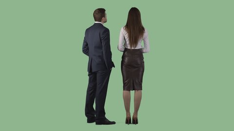 Male and young woman are standing in business clothes and looking at something. Back view. Clip with alpha channel