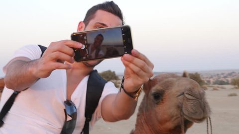 Man taking a selfie with a Camel in Desert