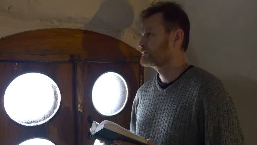 Close up View on a Man, Worshiper Near a Wooden Window. an Elderly Believer Prays in the Window of the Church in a Cold Chalk Cave. Tourist in Church, Chapel Inside the Chalk Cave. Man With Beard is