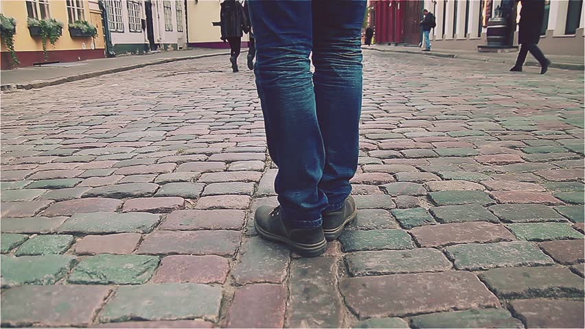 man in boots marching on the city road, pavement