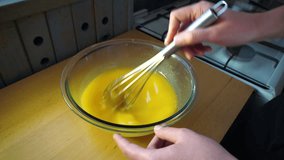 whisking the eggs to prepare the lemon Kurd. Cooking lemon meringue pie. Macro video whipping eggs
