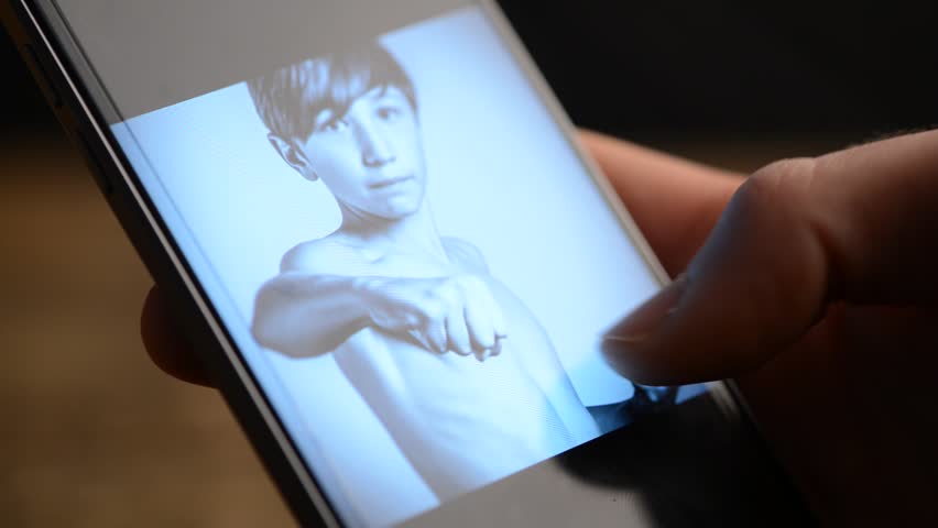 boy looks at photo gallery on his smartphone