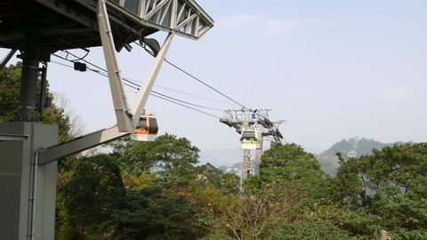 Rope transportation over lush rainforest area, top of mountain. Maokong gondola lift, view from top terminal station, and first pole.